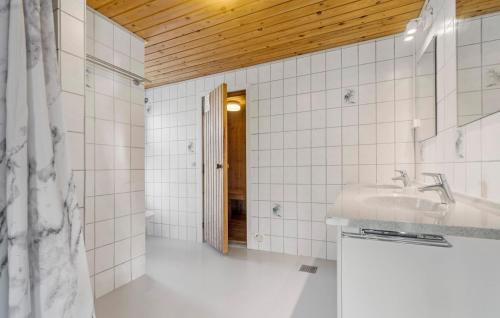 een witte badkamer met een wastafel en een spiegel bij 5 Bedroom Pet Friendly Home In Ebeltoft in Ebeltoft