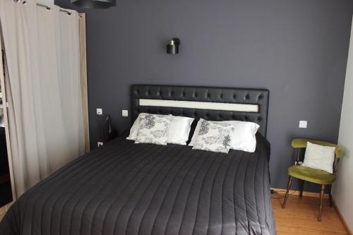 a bedroom with a black bed with white pillows at Chambre privée, Mer et Foret in Le Verdon-sur-Mer