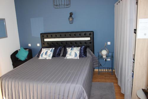 a bedroom with a large bed with blue walls at Chambre privée, Mer et Foret in Le Verdon-sur-Mer