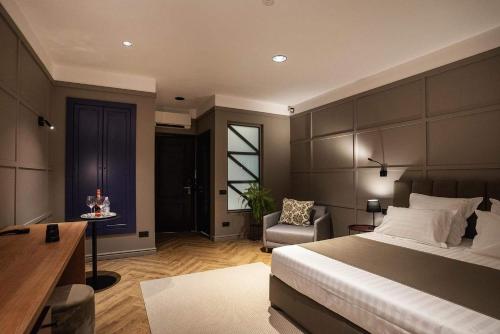a bedroom with a bed and a desk and a chair at Boutique ALNIS in Constanţa