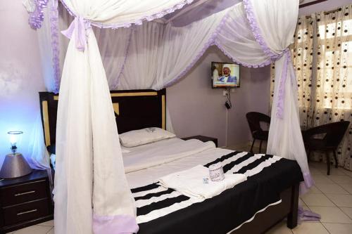 a bedroom with a bed with a canopy at Madola Hotel in Nairobi