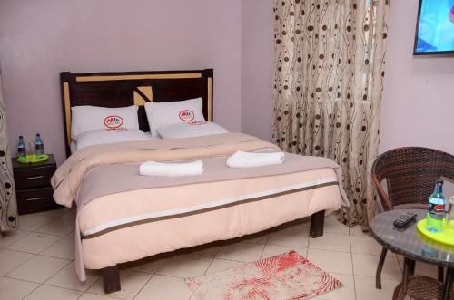 a bedroom with a bed with two towels on it at Madola Hotel in Nairobi