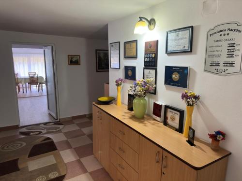 a room with a counter with flowers in vases on it at Pensiunea Marydor in Gîrda de Sus