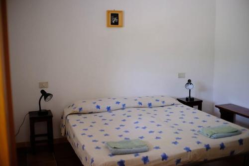 - une chambre avec un lit et une couette bleue dans l'établissement Artist House, à Cardedu