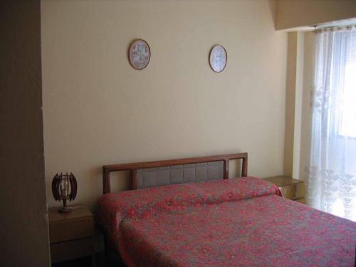 1 dormitorio con 1 cama y 2 relojes en la pared en La soñada en Mar de Ajó