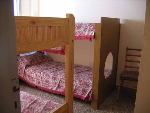 1 dormitorio con 2 literas y 1 silla en La soñada en Mar de Ajó