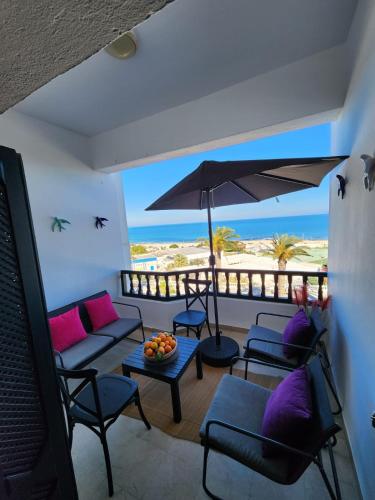 a living room with a view of the beach at L'univers de la mer appartement in Douar el Hafey