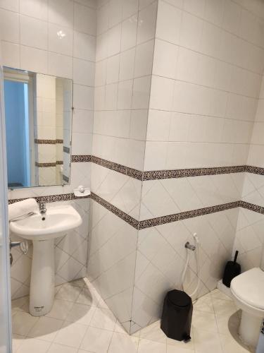 a bathroom with a sink and a toilet at L'univers de la mer appartement in Douar el Hafey
