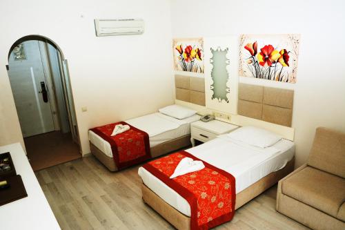 a small room with two beds and a couch at MIRAMOR HOTEL & Spa - ULTRA ALL INCLUSIVE SELECTION in Kemer