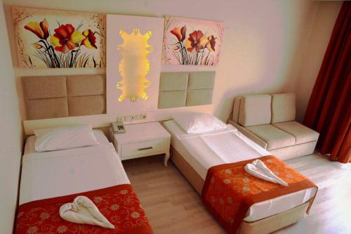 a small room with two beds and a couch at MIRAMOR HOTEL & Spa - ULTRA ALL INCLUSIVE SELECTION in Kemer