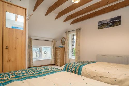 a bedroom with two beds and a window at Wern-Fawr in Betws-y-coed