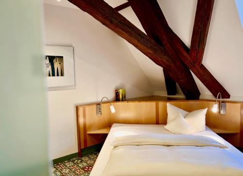 a bedroom with a bed with a wooden headboard at Hotel Münchner Hof und Blauer Turm in Regensburg