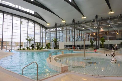 a large indoor swimming pool in a building at Appartement 2, Jardin, collation, 5 min de l'aéroport CDG in Le Mesnil-Amelot