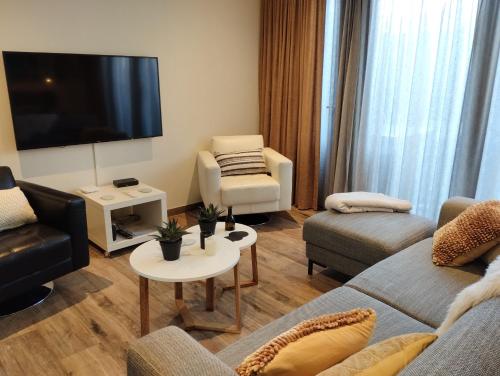 a living room with a couch and a flat screen tv at Aan't Strand Bed by the Sea Adults only in Westkapelle