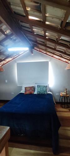 - une chambre avec un lit bleu dans l'établissement Estrela da Montanha 2, à Santo Antônio do Pinhal