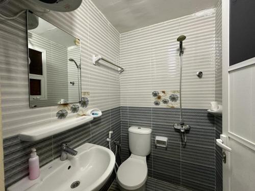 a bathroom with a toilet and a sink at Luluat Al Afia Hotel Apartments in Sur