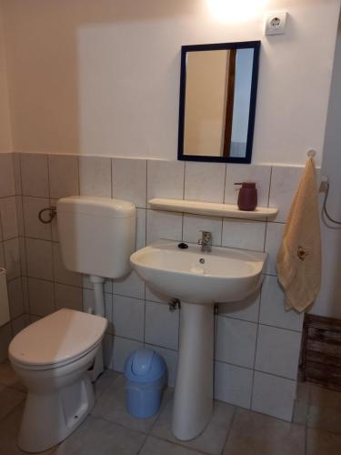 a bathroom with a toilet and a sink and a mirror at Szép-Lak Makó in Makó