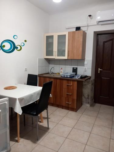 a kitchen with a white table and chairs and a counter at Szép-Lak Makó in Makó