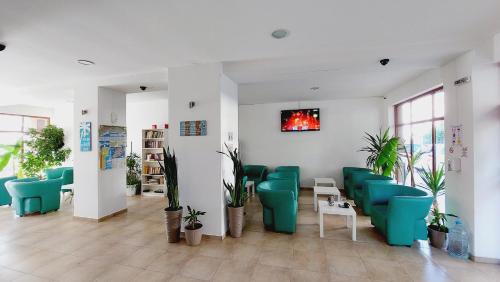 a waiting room with green chairs and plants at Diamond Palace in Sunny Beach