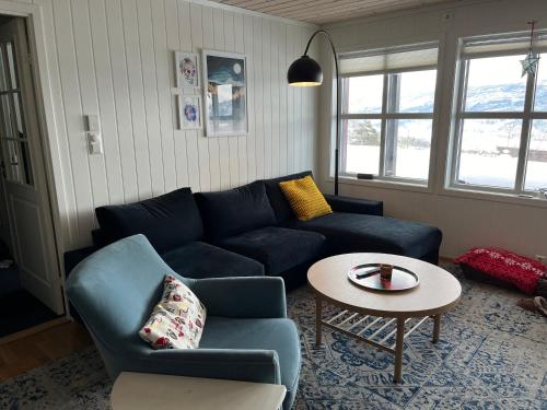 uma sala de estar com um sofá azul e uma mesa em Voss Resort - 2br vacation apartment em Skulestadmo