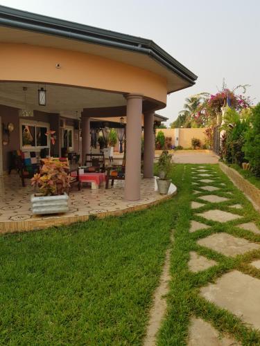 ein Haus mit einem Steinweg, der auf eine Terrasse führt in der Unterkunft Nana Adu Guest House in Koforidua