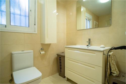 a bathroom with a toilet and a sink and a mirror at Villa Jazmin in Fuengirola