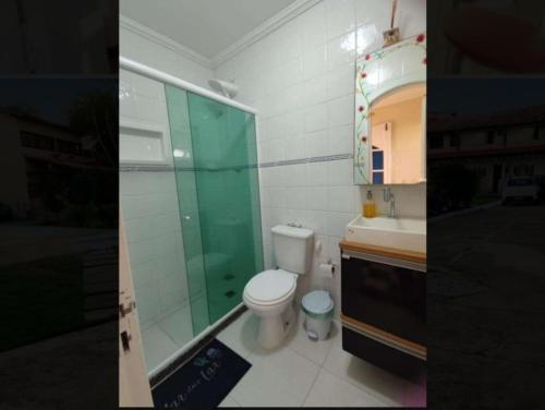 uma casa de banho com um WC, um chuveiro e um lavatório. em Kitnet da lug em Cabo Frio