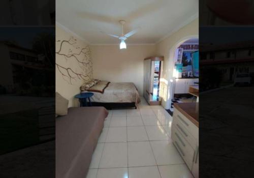 duas fotografias de um quarto com uma cama em Kitnet da lug em Cabo Frio