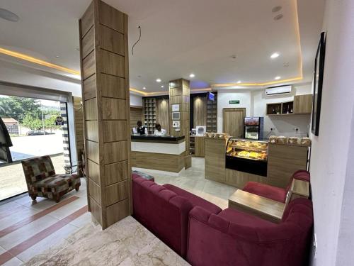 a living room with a purple couch and a kitchen at Hotel 5092 in Abuja