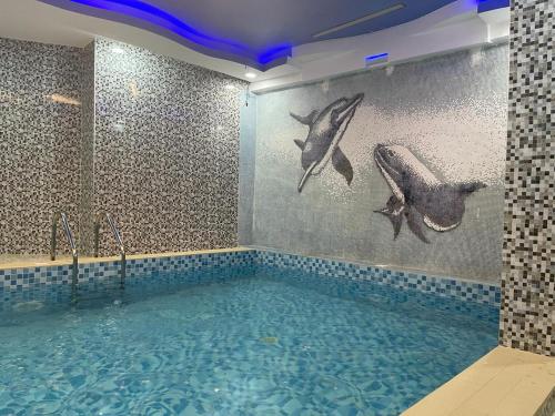 a bathroom with a swimming pool with fish on the wall at Hotel 5092 in Abuja