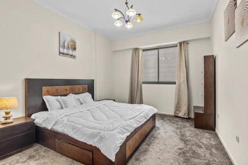 a bedroom with a large bed and a window at Modern living nestled with 1BR_Silicon Oasis Dubai in Dubai