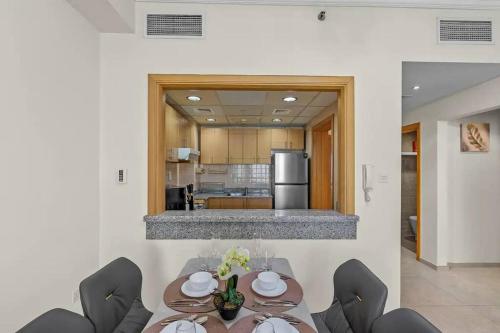 a dining room with a table and chairs and a kitchen at Modern living nestled with 1BR_Silicon Oasis Dubai in Dubai