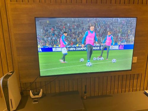 a tv screen with three soccer players on the field at Omah Apartments in Abuja