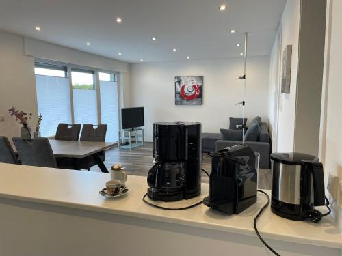 een keuken en een woonkamer met 2 koffiezetapparaten op een aanrecht bij Fewo Arnsberg-Müschede / eigener Eingang mit Terrasse und Fernblick in Arnsberg