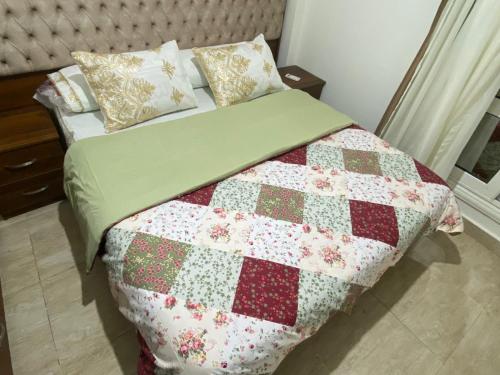 a bedroom with a bed with a quilt on it at Luxurious, fully furnished and well equipped apartment with modern amenities, stunning views, and convenient location for remote work or studying from home in Madinaty