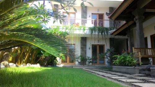 a house with a palm tree in front of it at Kubu Carik in Legian