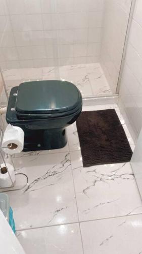 a bathroom with a green toilet and a black rug at Apartamento 2 quartos Rio Centro - Barra Olímpica in Rio de Janeiro