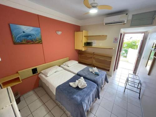 a bedroom with a bed with shoes on it at Pousada Recifes de Corais in Porto De Galinhas