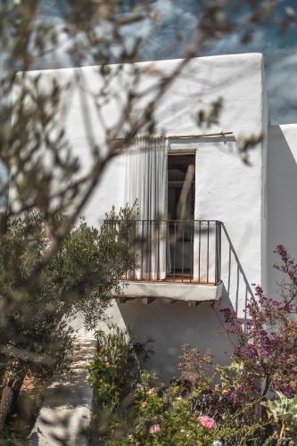 a small white building with a balcony with a porch at ES CUCONS RURAL HOTEL in San Antonio