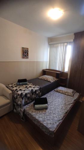 ジュイス・デ・フォーラにあるApto São Pedro, pertinho UFJFのベッド2台とソファが備わる客室です。