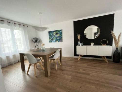 une salle à manger avec une table et un miroir dans l'établissement Chez Marie-Jeanne, à Étrechet