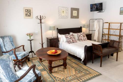 1 dormitorio con 1 cama, mesa y sillas en Hummingbird, en Pretoria