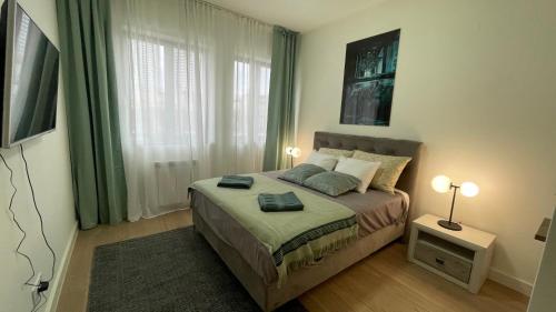 a bedroom with a bed and two lamps and a window at Skala Waterfront - Beograd na vodi in Belgrade