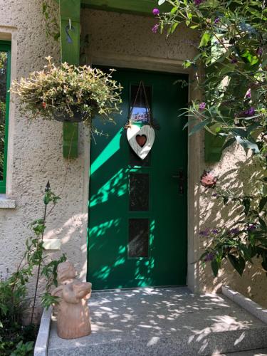a green door of a house with a window at Little Cottage auf 2 Etagen in Raben Steinfeld