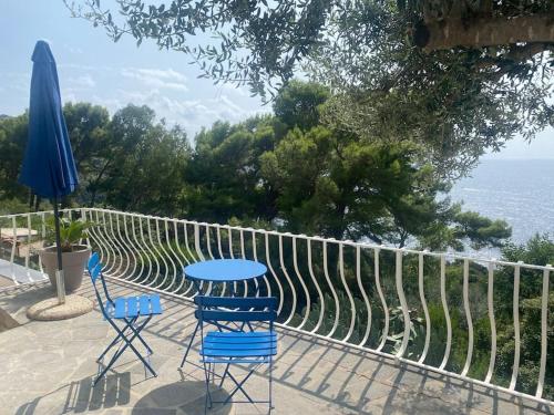 a patio with two chairs and a table and an umbrella at La GEMMA di Orrico in Anacapri