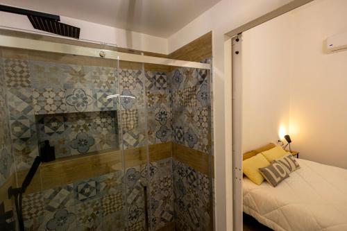 La salle de bains est pourvue d'une douche, d'un lit et d'une porte en verre. dans l'établissement Casa Lella Holiday Boutique, à Palerme