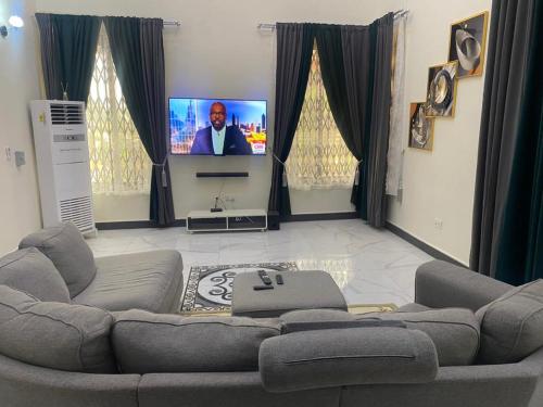uma sala de estar com um sofá e uma televisão de ecrã plano em DUKU MANSION em Pantang