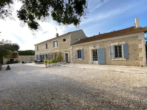 an exterior view of a stone house with a driveway at Gite Provençal du Mas Arnaud in Arles