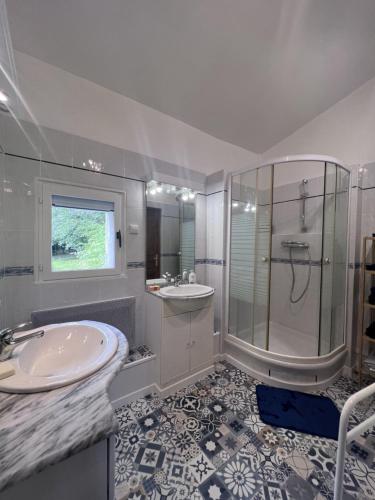 a white bathroom with a sink and a shower at Bienvenue Chez Vous in Émancé