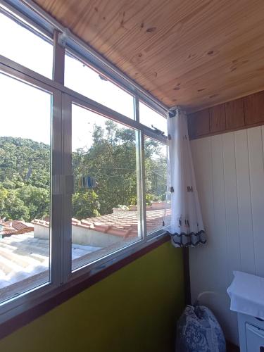 ein Fenster in einem Zimmer mit Aussicht in der Unterkunft Casa Dell Angelo Apartamentos in Visconde De Maua